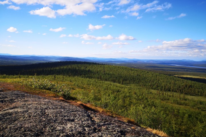 Scenic view of a forested landscape with distant mountains and a clear sky.