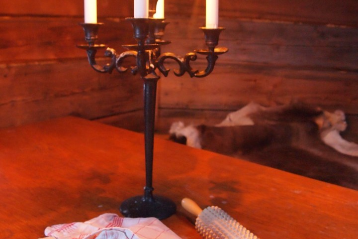 Candlelit table with crispbread, rolling pin, and five lit candles.
