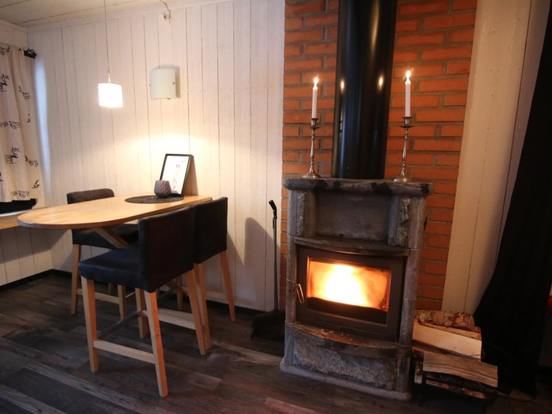 Cozy room with wood-burning stove, round table, and two chairs.