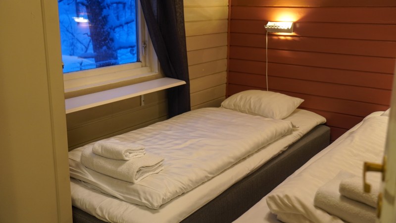 Cozy room with two twin beds, folded towels, and warm lighting.