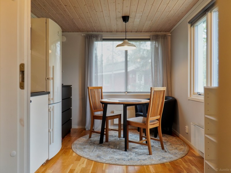 Cozy dining area with round table, two chairs, and a window.